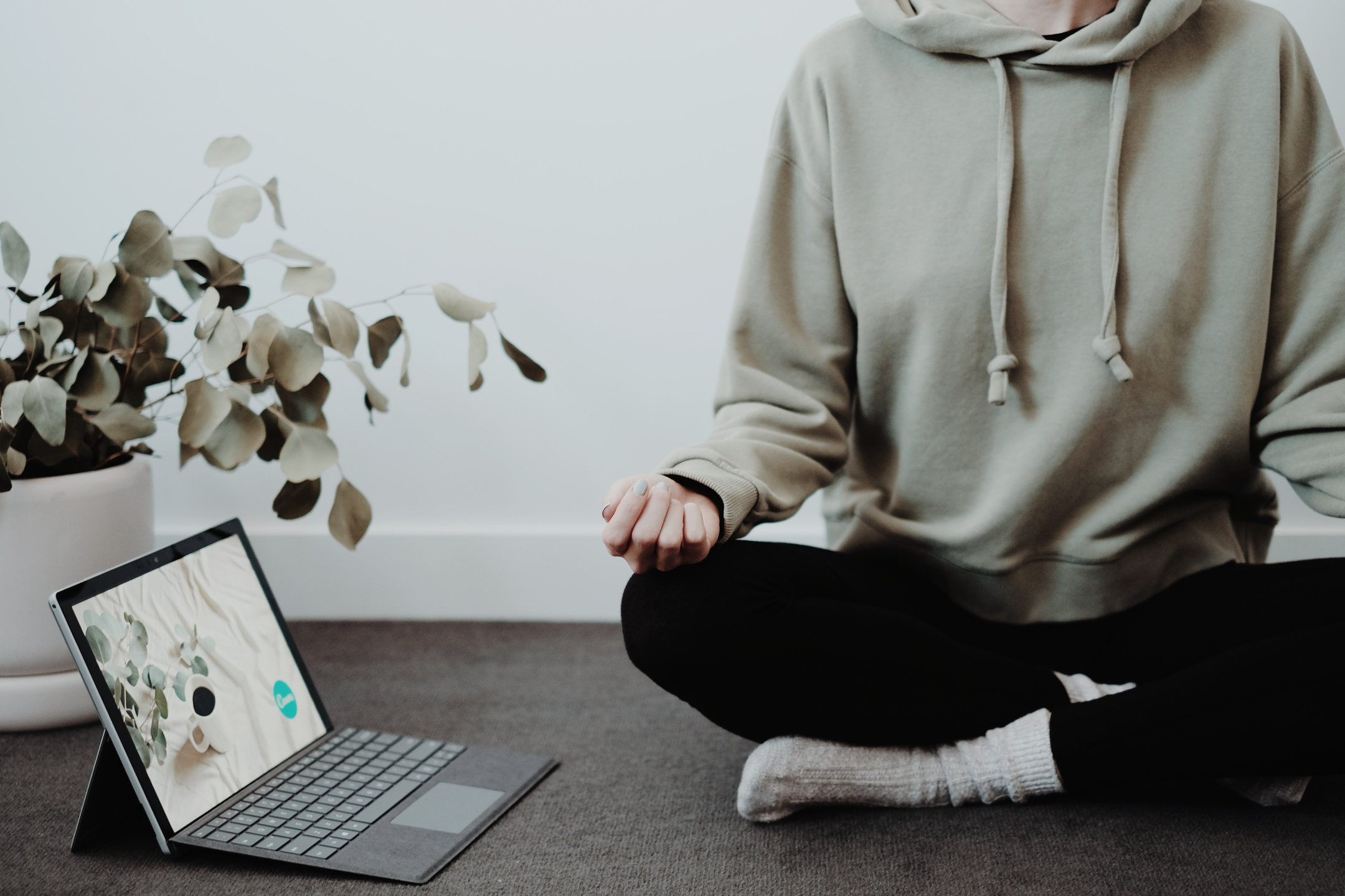 Woman meditating beside tablet 